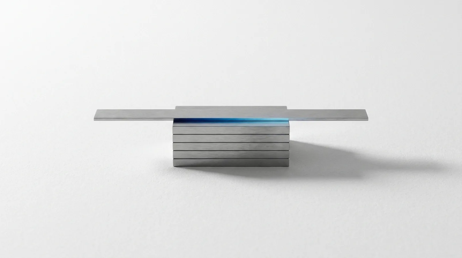 Precision gauge blocks wrung into one stack, with a reference straightedge in contact along its whole top face.