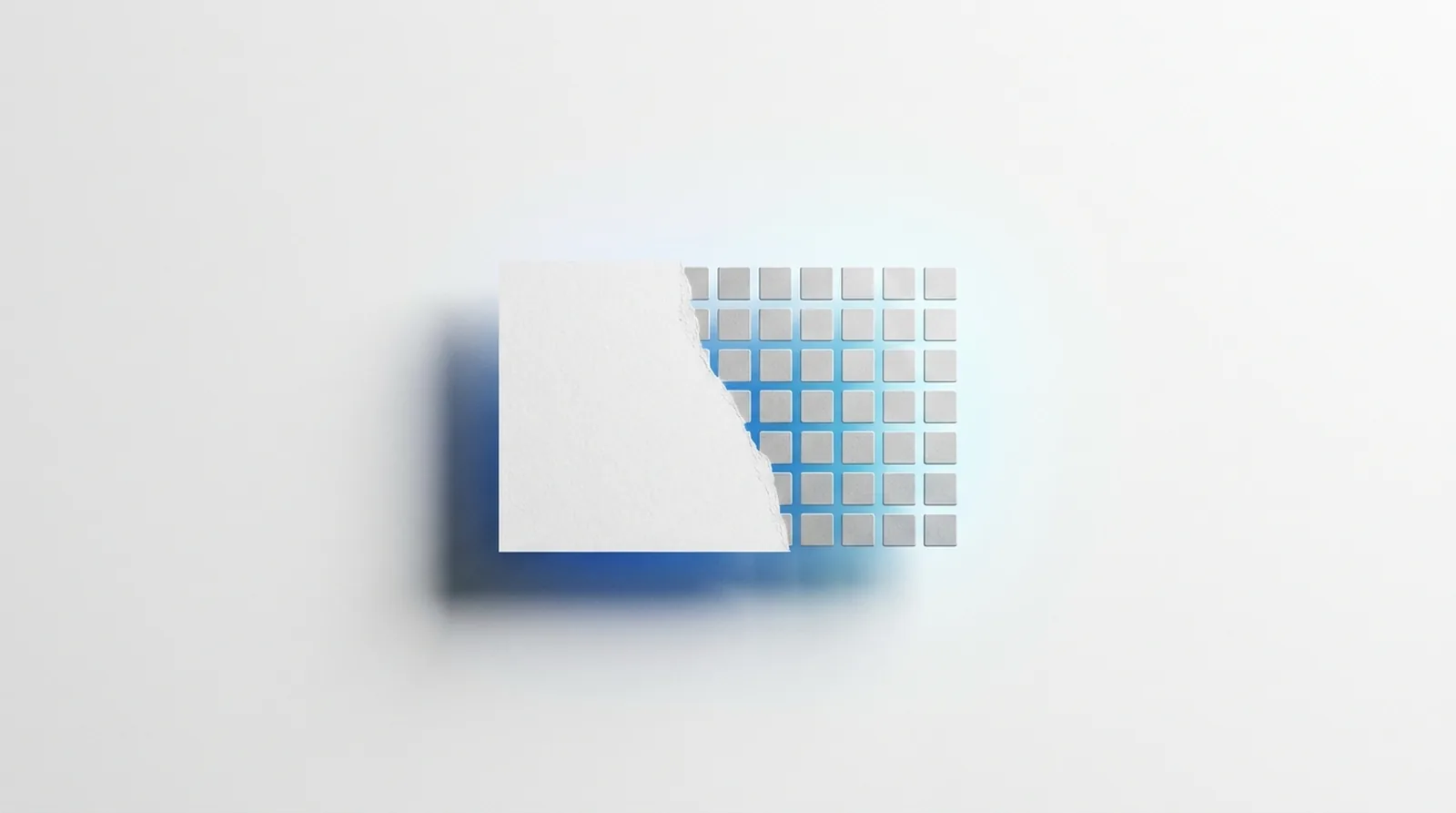 A sheet of white material whose edge dissolves into an exact grid of small machined tiles.