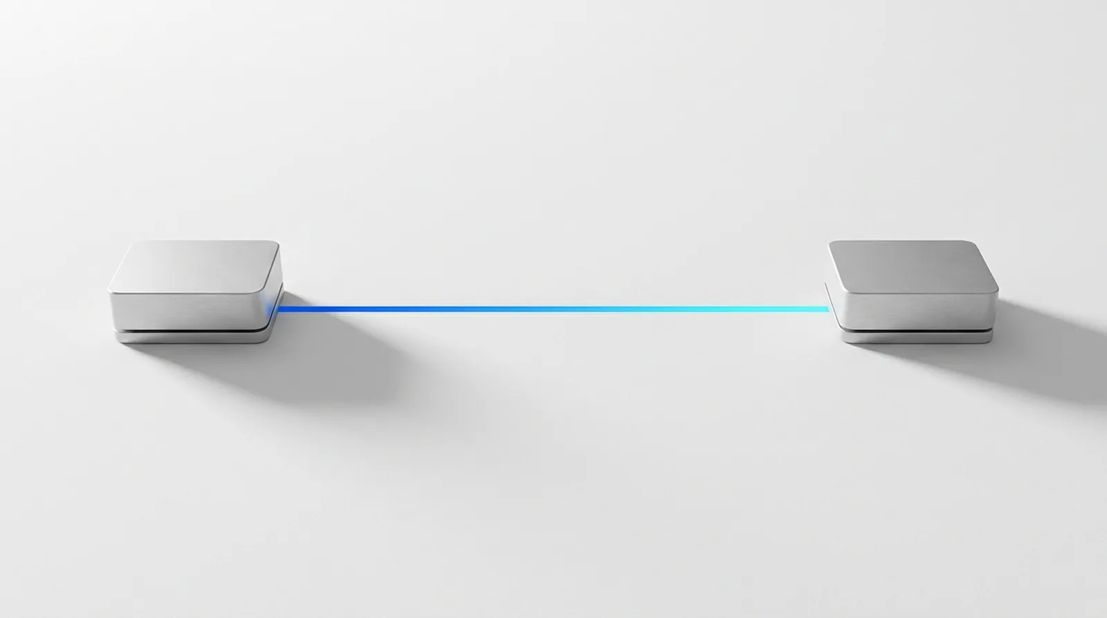 Two separate machined housings on a white ground, joined across the gap between them by a single unbroken channel of blue light.