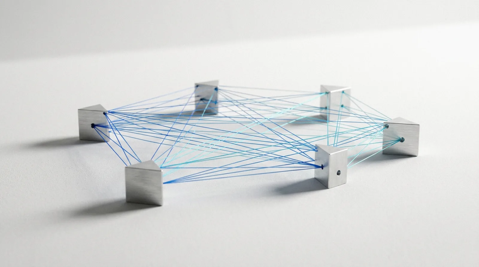 Several separate machined units on a white ground joined directly to each other by fine lit filaments, with no central hub.