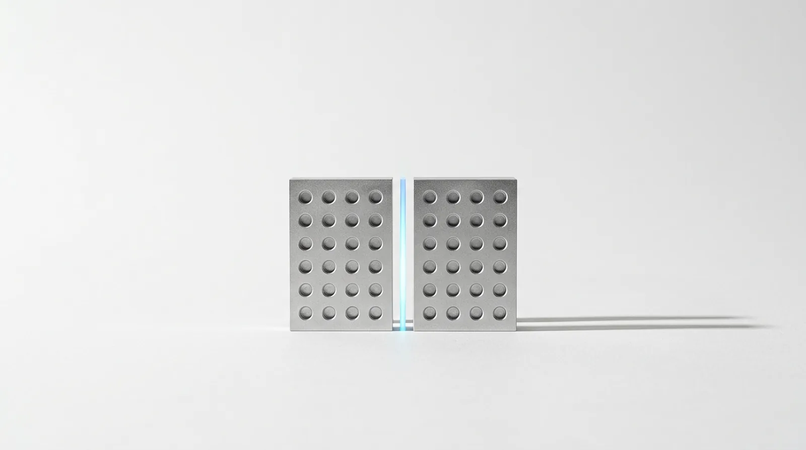Two machined plates facing each other with identically registered milled recesses, held in agreement by a single channel of light between them.